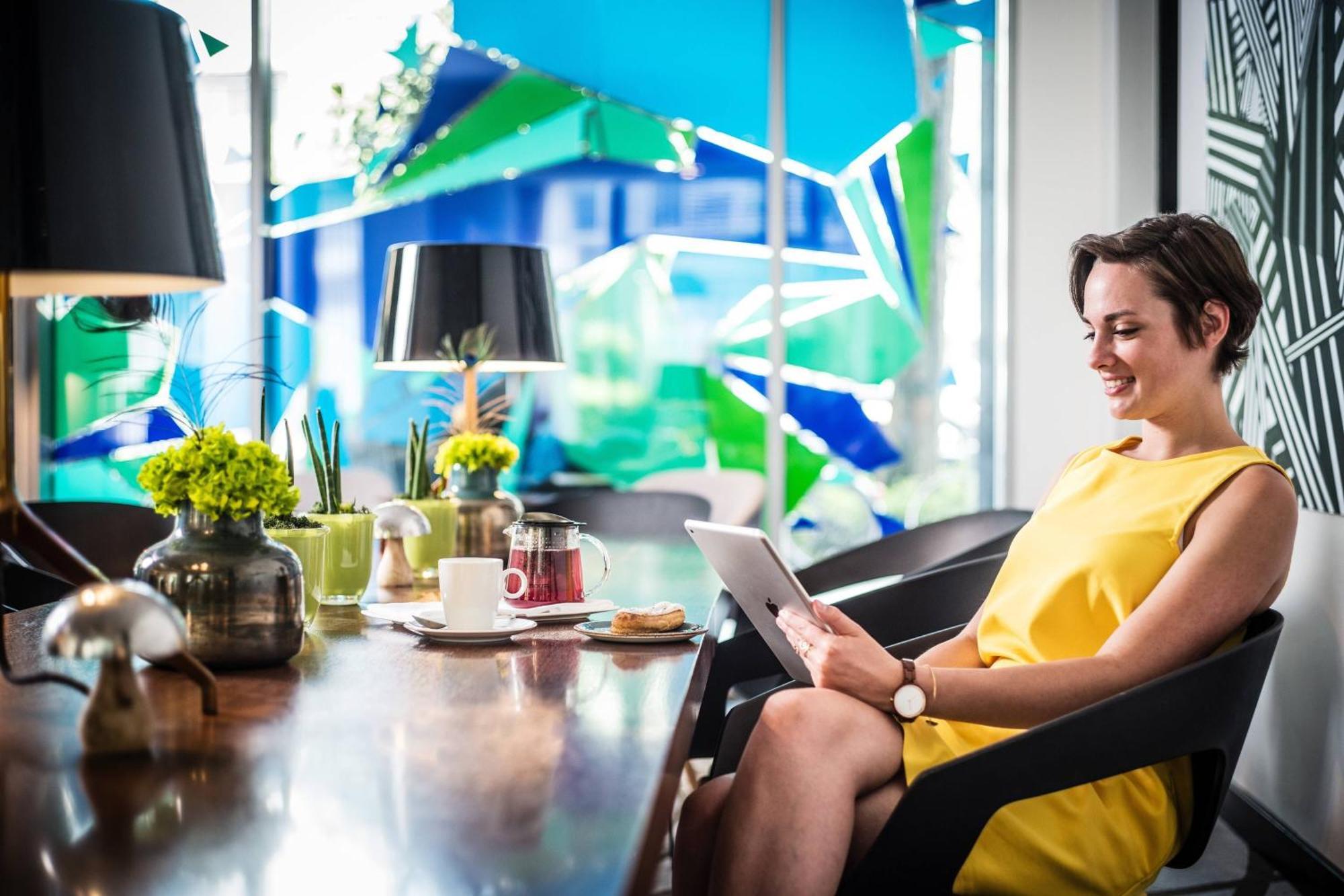 Le Meridien Munique Exterior foto A woman using a tablet